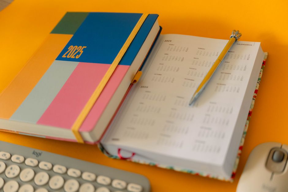 Vibrant 2025 planner and calendar on a desk setup for organization and planning.
